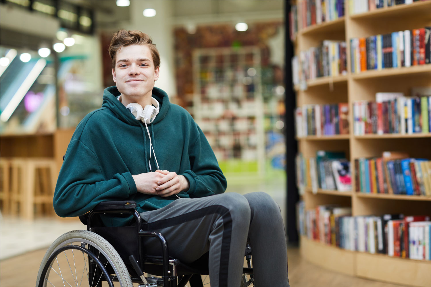 smiling young man in a wheelchair at a library